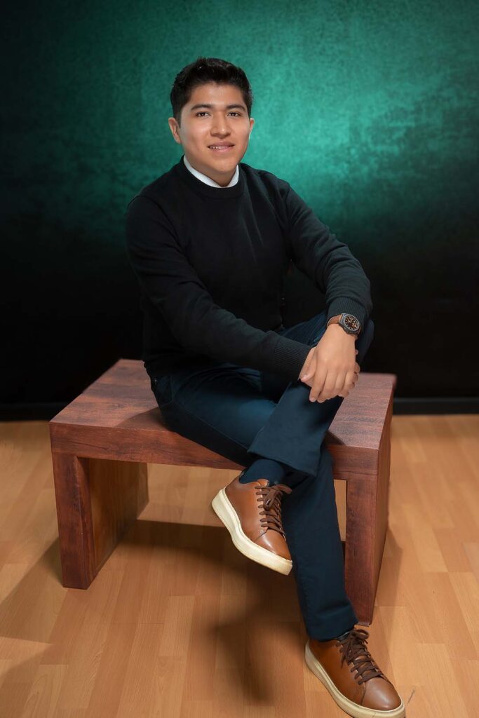 Retrato profesional de hombre sentado sobre fondo verde, foto corporativa en estudio, Barranco