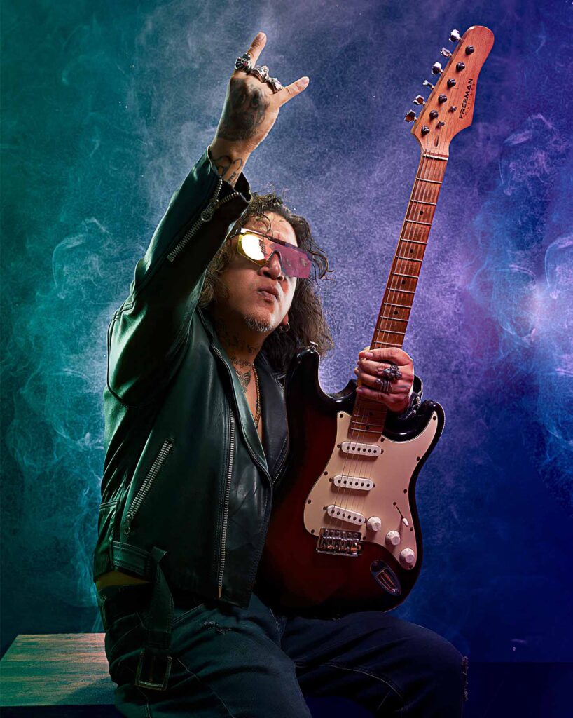 Guitarrista de rock con gafas oscuras y guitarra eléctrica en estudio