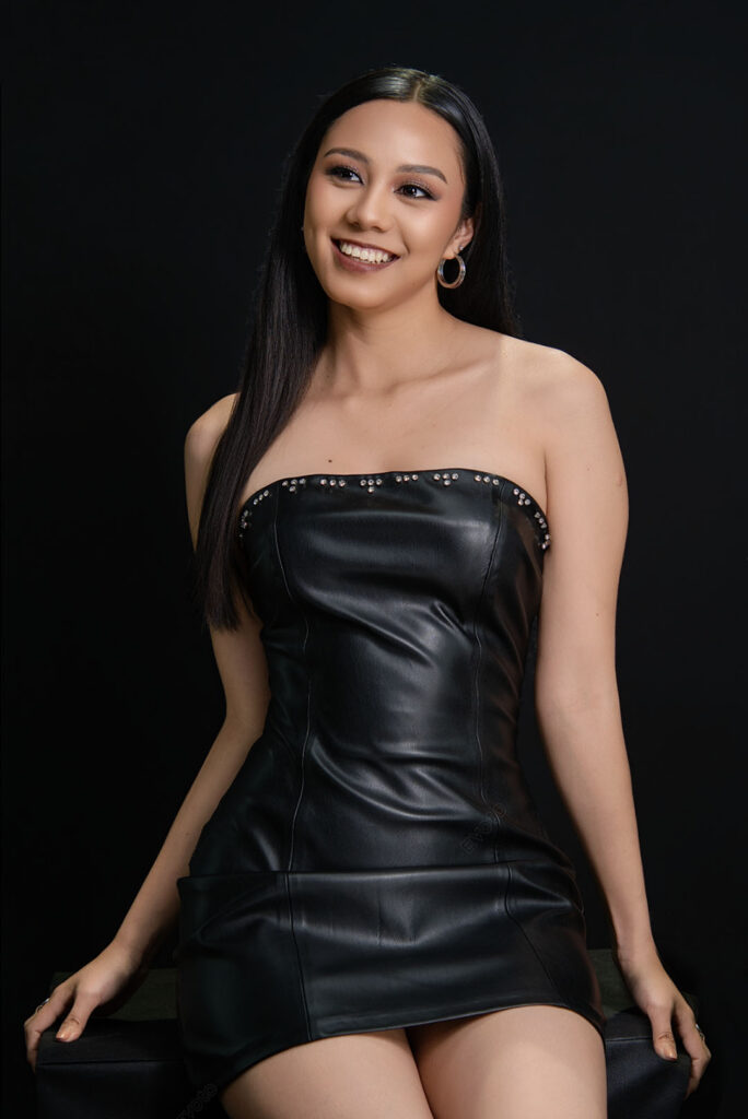Retrato creativo de mujer de pie con vestido negro palabra de honor, estudio en Lima