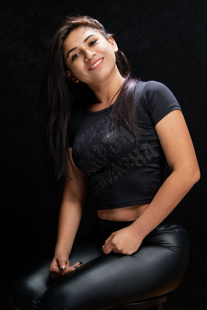 Retrato creativo sentada, luz suave sobre fondo oscuro, estudio fotográfico en Barranco